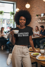 Model wearing the Adulting Is A Scam black crop top in an indoor cafe setting
