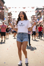 Model wearing the America Est. 1776 Crop Top with denim shorts in a city street scene