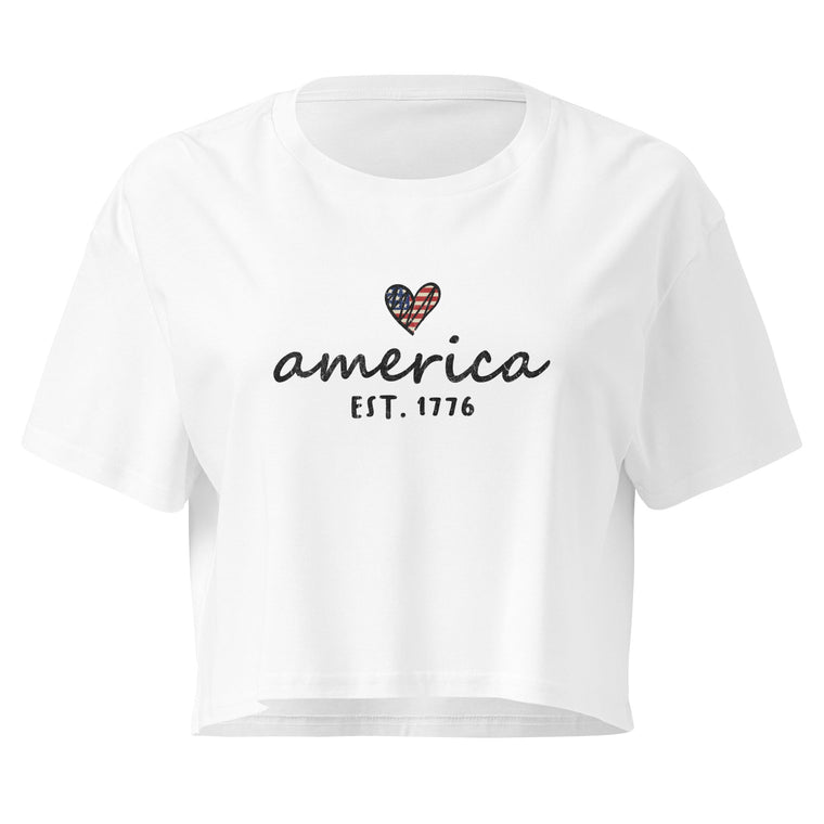 America Est. 1776 white crop top front product mockup with minimal patriotic script graphic