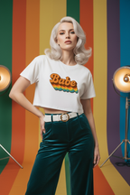 Model wearing the Babe Retro Rainbow Crop Top in a retro striped studio scene with green trousers