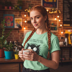 Woman holding a mug in a cozy room with plants and string lights.