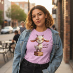 Woman wearing a purple t-shirt with a cartoon goat graphic and text, standing on a city street.