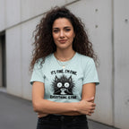 Woman wearing a light blue t-shirt with a graphic and text, standing against a plain background.