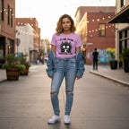 Woman wearing a pink t-shirt with a cat graphic and text, standing on a street.