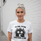 Woman wearing a white t-shirt with a graphic and text against a white wall.