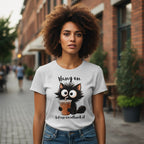Woman wearing a t-shirt with a cat graphic and text in an urban setting
