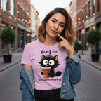 Woman wearing a pink t-shirt with a cat graphic and text on a city street.