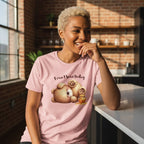 Woman wearing a pink t-shirt with a cartoon bear design and text in a kitchen setting