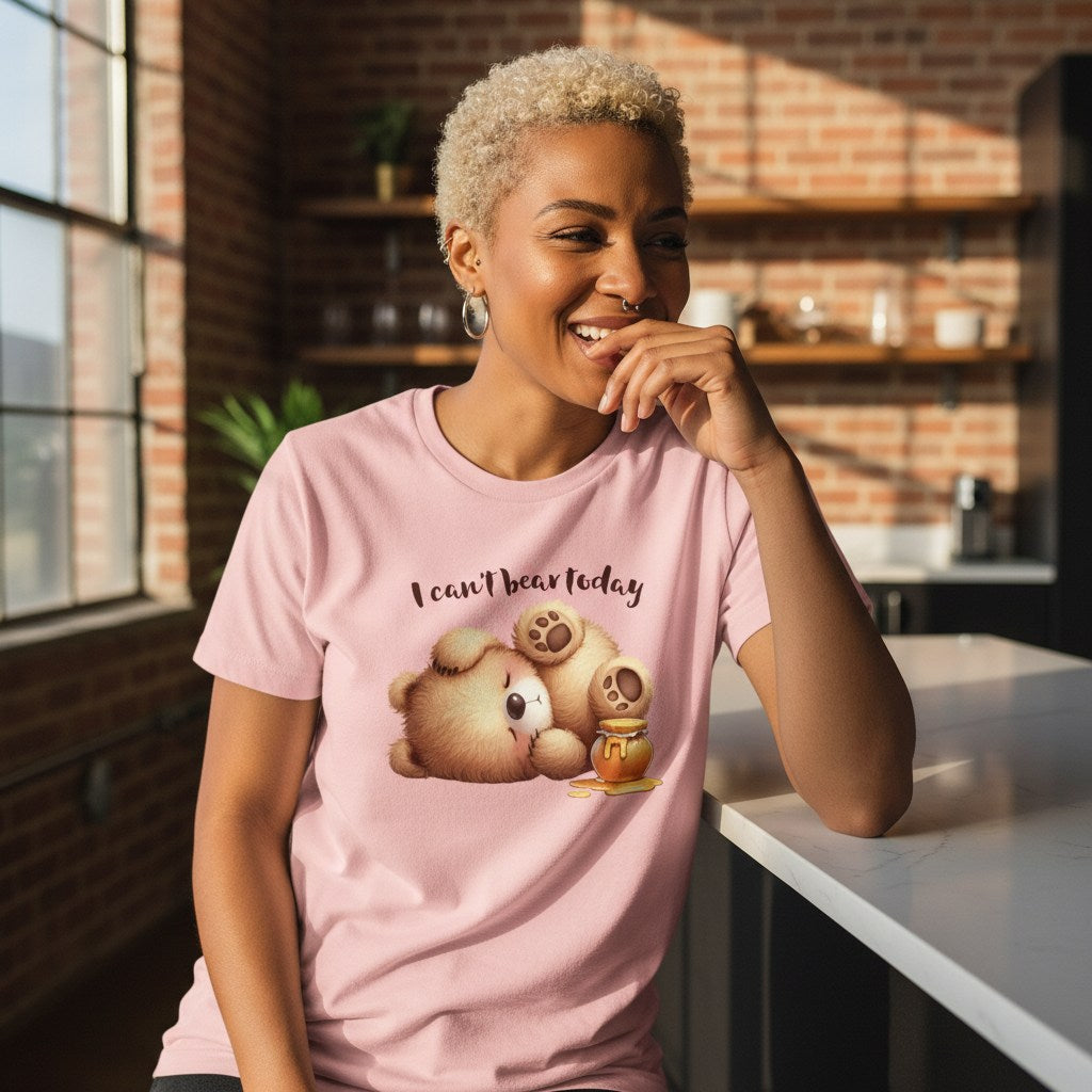 Woman wearing a pink t-shirt with a cartoon bear design and text in a kitchen setting