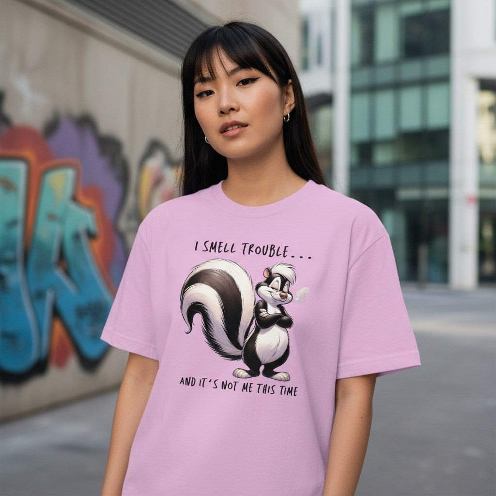 Person wearing a pink t-shirt with a skunk graphic and text in an urban setting