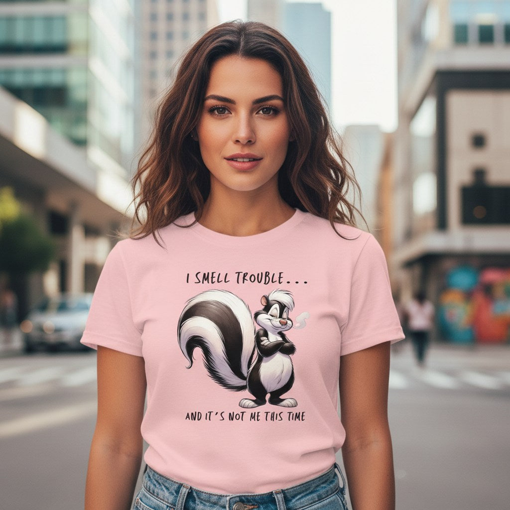 Woman wearing a pink t-shirt with a skunk graphic and text on a city street.