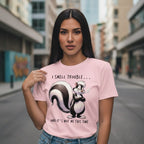 Woman wearing a pink t-shirt with a skunk graphic and text in an urban setting