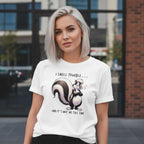 Woman wearing a white t-shirt with a skunk graphic and text in an urban setting