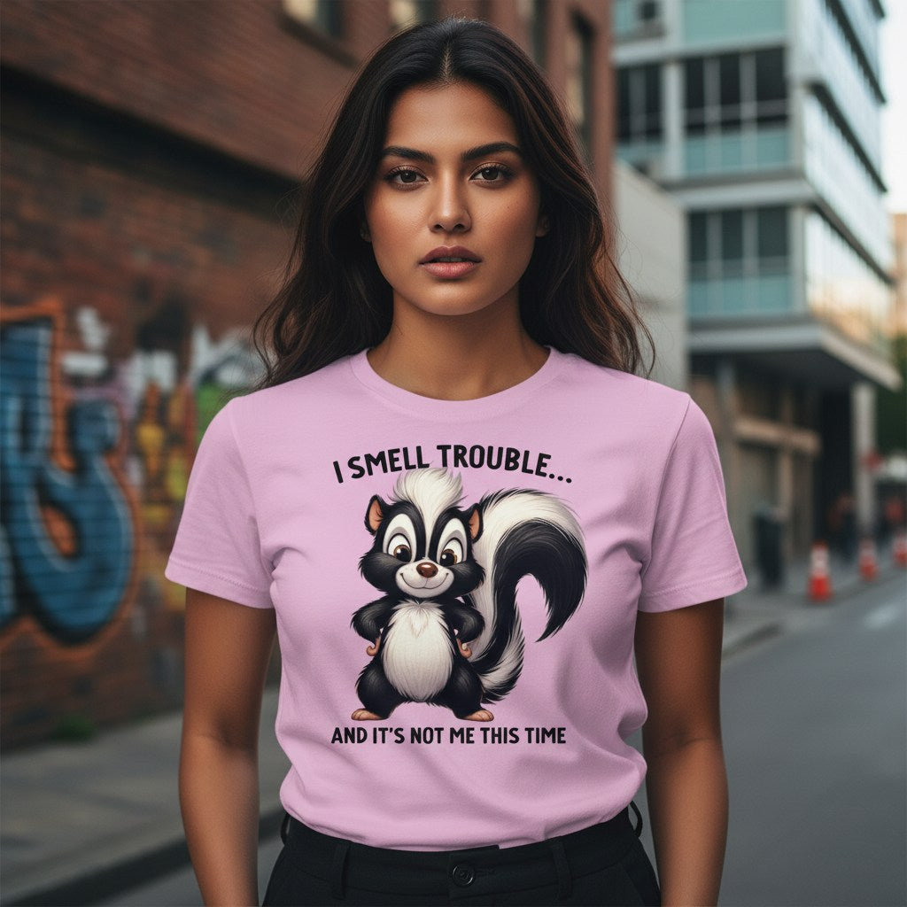 Woman wearing a pink t-shirt with a skunk graphic and text in an urban setting