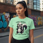 Woman wearing a green t-shirt with a skunk graphic and text in an urban setting