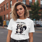 Woman wearing a white t-shirt with a skunk graphic and text on a city street.