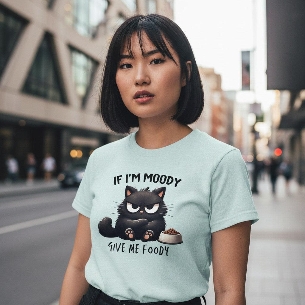Woman wearing a light blue t-shirt with a black cat graphic and text on a city street.
