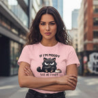 Woman wearing a pink t-shirt with a cat graphic and text in an urban setting