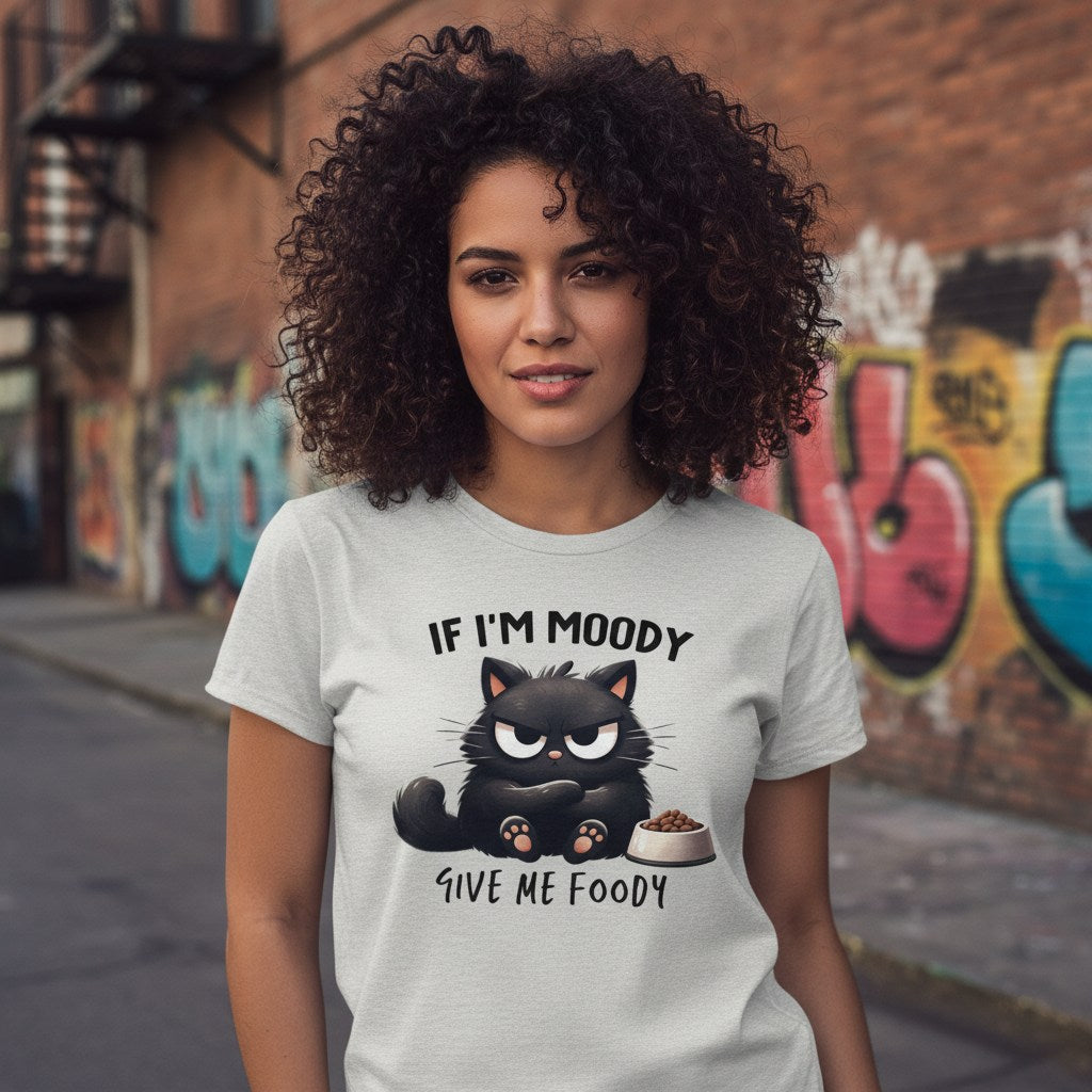 Person wearing a t-shirt with a cat graphic and text in an urban setting