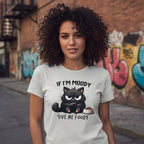 Person wearing a t-shirt with a cat graphic and text in an urban setting