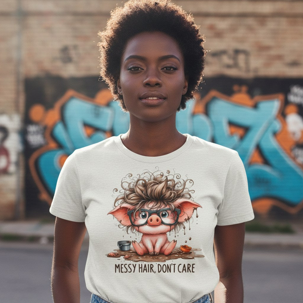 Person wearing a t-shirt with a cartoon pig design and text 'Messy Hair, Don't Care' in front of graffiti.