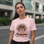 Woman wearing a pink t-shirt with a cartoon pig design and text 'Messy Hair, Don't Care' on a city street.