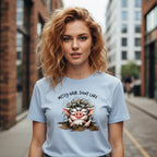 Woman wearing a light blue t-shirt with a cartoon pig design and text on a city street.