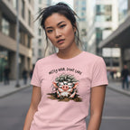 Woman wearing a pink t-shirt with a cartoon pig design and text in an urban setting