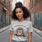 Woman wearing a t-shirt with a cartoon pig and text in an urban setting