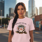 Woman wearing a pink t-shirt with a cartoon pig design and text in an urban setting
