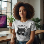Person wearing a t-shirt with a cat graphic and text in an office setting