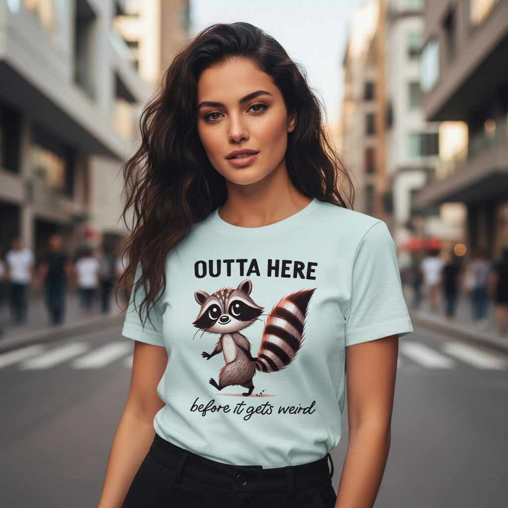 Woman wearing a light blue t-shirt with a raccoon graphic and text on a city street.