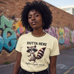 Person wearing a t-shirt with a raccoon graphic and text in an urban setting