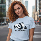 Woman wearing a light blue t-shirt with a panda graphic and text in an urban setting