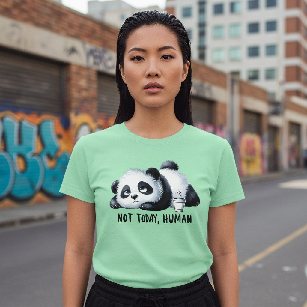 Woman wearing a light green t-shirt with a panda graphic and text in an urban setting