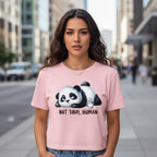 Woman wearing a pink t-shirt with a panda graphic and text on a city street.