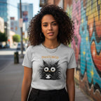 Person wearing a t-shirt with a cartoon character and text, standing in an urban setting with graffiti.