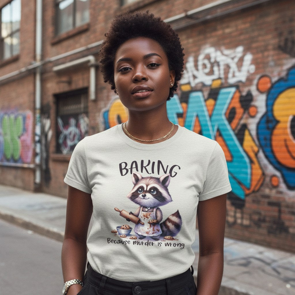 Person wearing a t-shirt with a raccoon graphic and text, standing in front of a graffiti-covered wall.