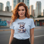 Woman wearing a light blue t-shirt with a raccoon graphic and text, standing in an urban setting.