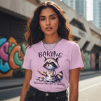 Woman wearing a purple t-shirt with a raccoon graphic and text, standing in an urban setting with graffiti.