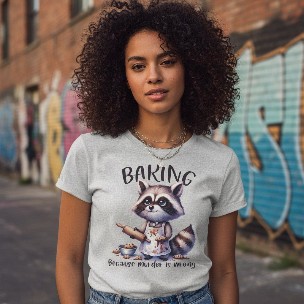 Person wearing a t-shirt with a raccoon graphic and text in an urban setting with graffiti.