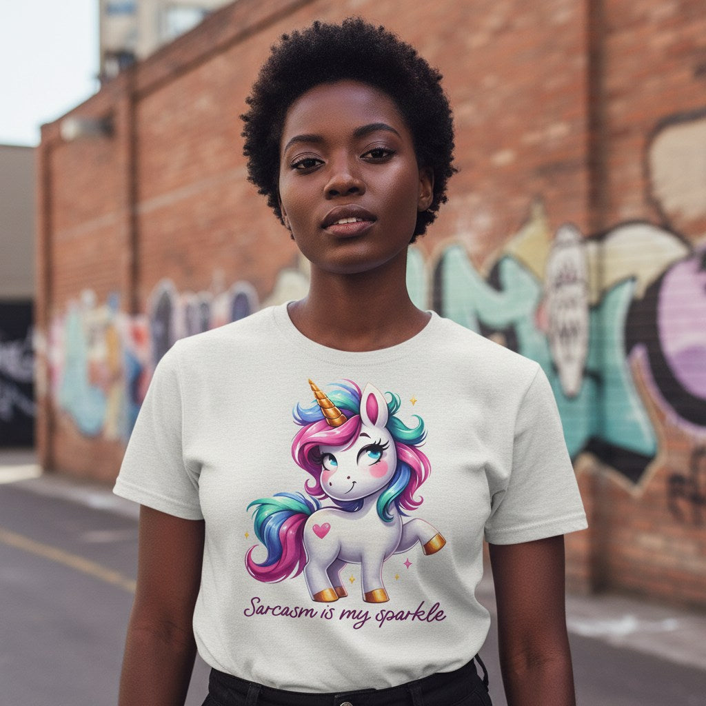 Person wearing a white t-shirt with a unicorn graphic and text, standing in front of a graffiti-covered wall.