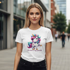 Woman wearing a white t-shirt with a colorful unicorn design on a city street.