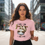 Woman wearing a pink t-shirt with a sloth graphic and text on a city street.