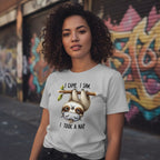 Person wearing a t-shirt with a sloth graphic and text in an urban setting with graffiti.