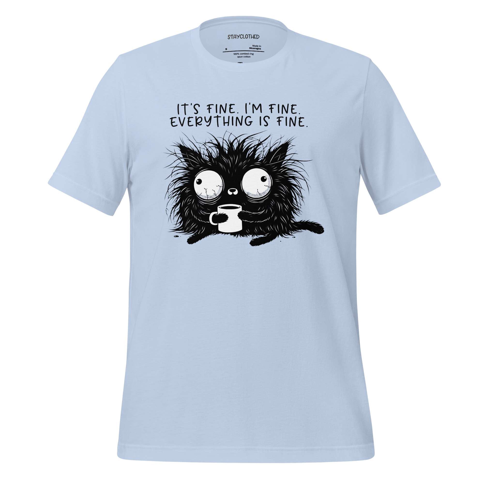 White t-shirt with a black cat graphic and text on a wooden surface, featuring the brand 'StayClothed'.