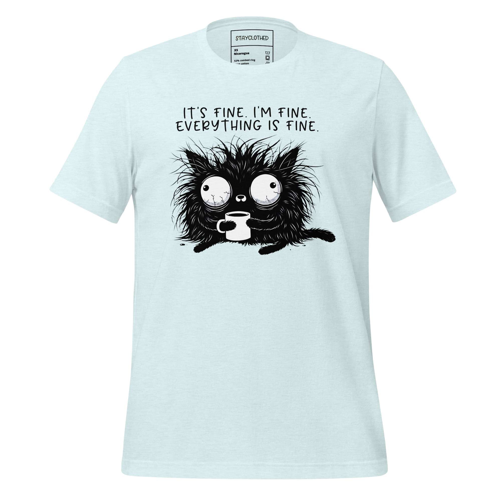 White t-shirt with a black cat graphic and text on a wooden surface, featuring the brand 'StayClothed'.