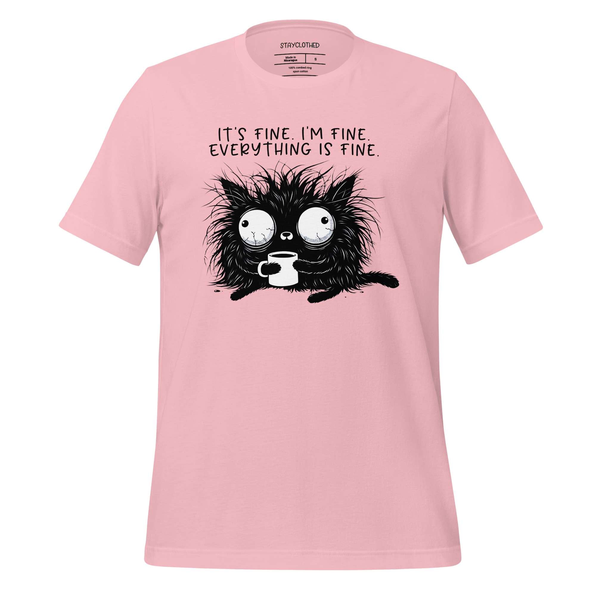 Pink t-shirt with a black cat graphic and text on a wooden surface, featuring the brand 'StayClothed'.