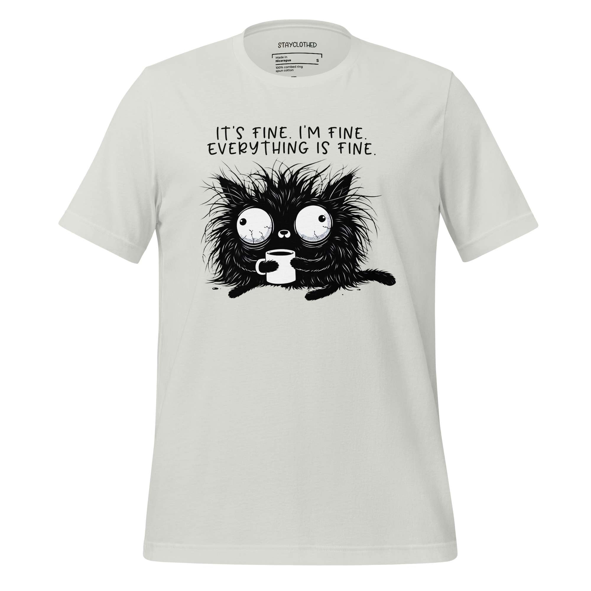 White t-shirt with a black cat graphic and text on a wooden surface, featuring the brand 'StayClothed'.