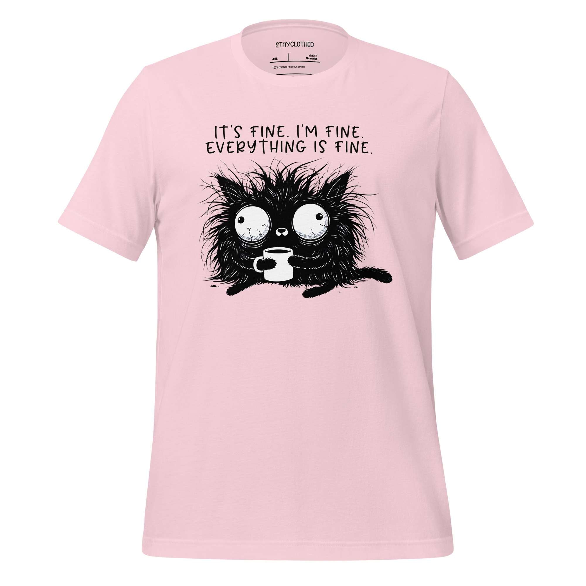 Pink t-shirt with a black cat graphic and text on a wooden surface, featuring the brand 'StayClothed'.